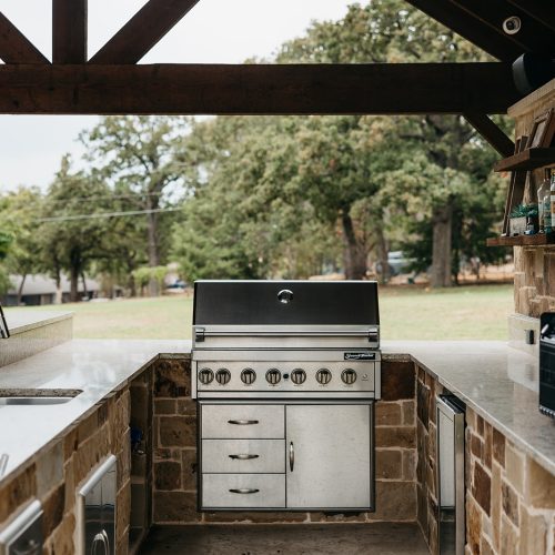 Stone Outdoor Kitchen with Bar Seating in Gunter TX